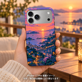サンセットピクセルシティ柄のケースを装着したiPhone 17 Proを手に持つ装着イメージ