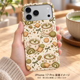 抹茶ビスケット柄のケースを装着したiPhone 17 Proを木のテーブルのそばで手に持つ装着イメージ